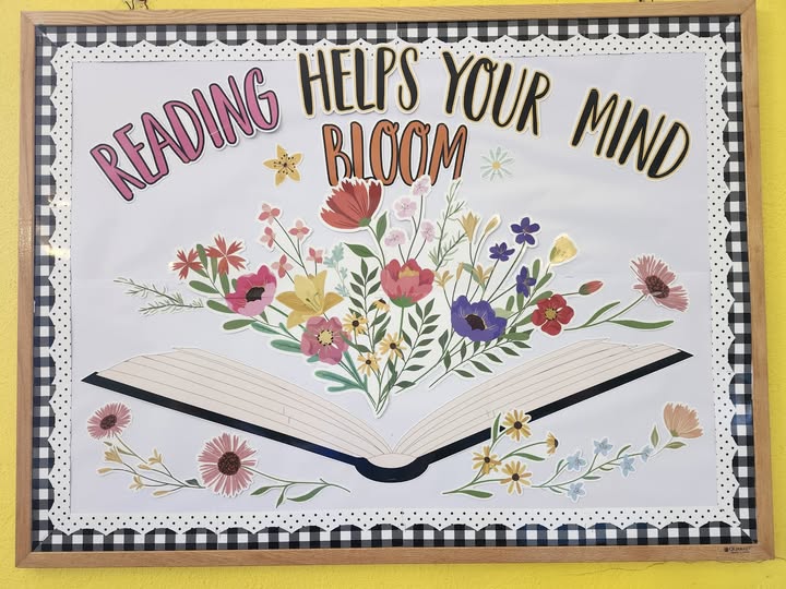 bulletin board saying "Reading Helps your Mind Bloom" with white background and paper cutouts of flowers